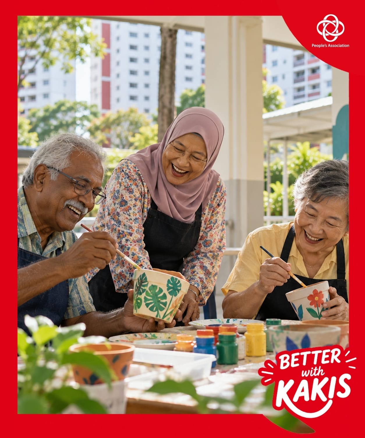 Three smiling seniors painting flower pots together outdoors. People’s Association ‘Better with Kakis’ campaign.